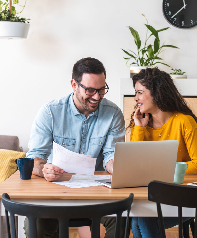 Smiling couple managing finances, reviewing their bank accounts